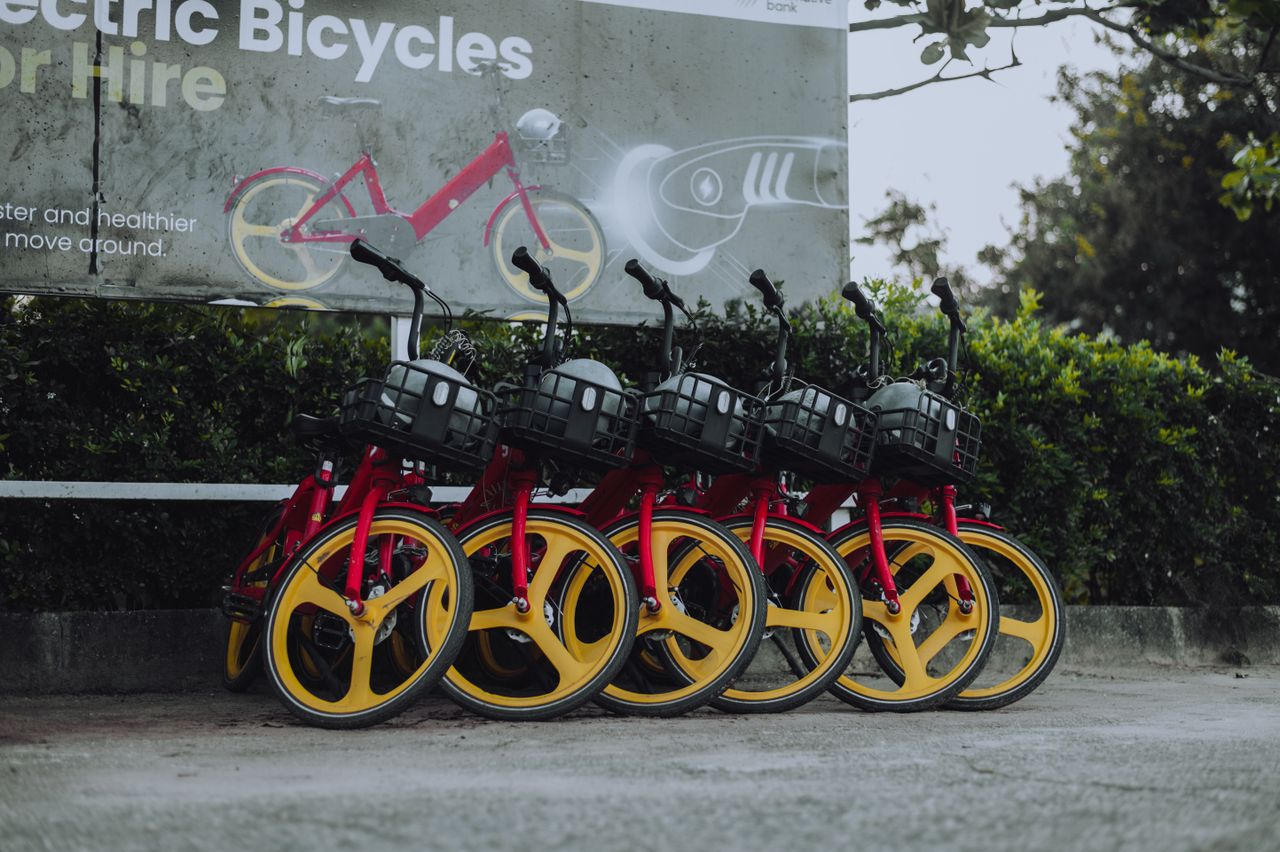 who-we-are Vibrant red and yellow electric bicycles parked outside, promoting eco-friendly transport.
